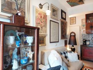 米兰MAISON DE CHARME MILANO的客厅配有沙发和带花瓶的架子