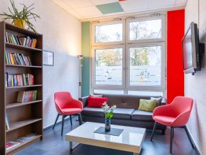 柏林Good Morning Berlin City West的客厅配有沙发和2把红色椅子