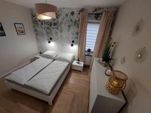 加茨比亚格拉Natura Resort "Bałtycki Sen"的一间卧室设有一张大床和一个窗户。