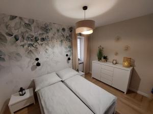 加茨比亚格拉Natura Resort "Bałtycki Sen"的一间卧室设有一张床和花墙