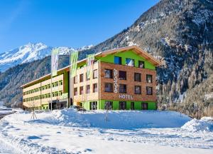 乌姆豪森Explorer Hotel Ötztal的山前有雪的酒店