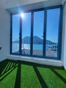 丽水市Yeosu Blueara Premium Pool Villa的一间设有大窗户和绿草的客房