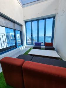 丽水市Yeosu Blueara Premium Pool Villa的客房设有沙发、桌子和窗户。