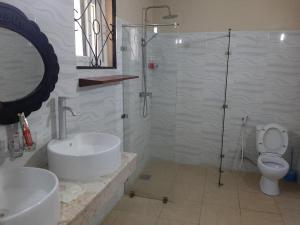 达累斯萨拉姆客及及海滩度假酒店的带淋浴、盥洗盆和卫生间的浴室