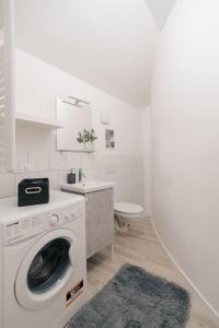 安科纳Loft Fred - by Casêta的白色的浴室设有洗衣机和水槽。