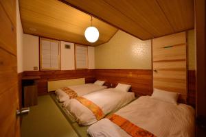 饭山市Raicho Lodge Madarao的卧室配有两张床,位于带门的房间