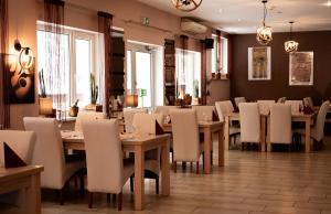姆拉哥沃High Class Suites Mazuria的配有木桌和白色椅子的餐厅