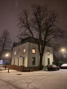 宾斯霍滕De Oude Pastorie的一座在晚上有树的建筑