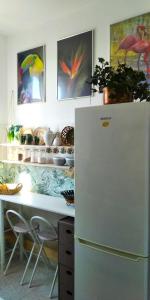 巴勒莫Casa Amari alla Zisa HOSTEL的厨房配有白色冰箱和带冰柜的桌子。