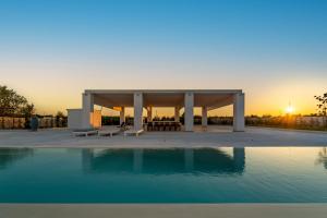 圣埃拉莫因科莱Villa Brigida Resort的日落前带游泳池的凉亭