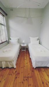 德班PHAKADEHOMES的铺有木地板的客房内的三张床