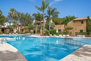 松霍里吉尔Menorca Paradise nº 30的一座拥有蓝色海水和棕榈树的游泳池