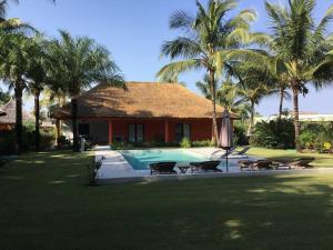 斯基灵角Villa avec piscine près de l'océan.的一座带游泳池和棕榈树的房子