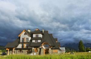 尤格Spiski Dworek的一片云天的田野中的房屋