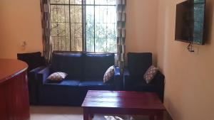 KwangwaziCamp Seluu - Safari Pkg的客厅设有蓝色的沙发和窗户。