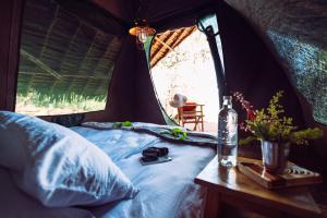Maji Moto玛姬摩托车生态帐篷营地的帐篷内的一张床位,桌子上装有一瓶
