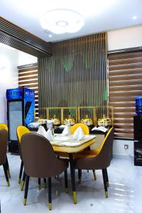 阿布贾Castle Estate APartments的一间带桌子和黄色椅子的用餐室