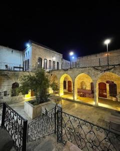 尚勒乌尔法Muzepotamia Butik Otel的石头建筑,晚上有庭院