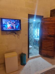 尚勒乌尔法Muzepotamia Butik Otel的浴室配有壁挂式电视和浴缸。