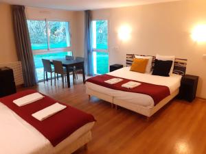 塞科斯La Villa des Golf.e.s的一间带两张床的卧室和一间带桌子的用餐室