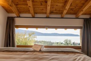 托斯科拉诺-马德尔诺Colago Private Villas Lake Garda的卧室设有窗户,床上有书
