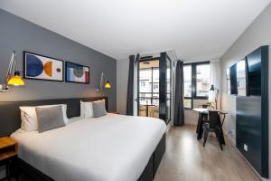 马赛Staycity Aparthotels Marseille Centre Vieux Port的酒店客房设有一张大床和一张书桌。