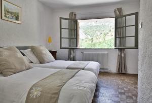 Saint-Antonin-sur-Bayons勒莫林恩普罗旺斯酒店的带大窗户的客房内的两张床