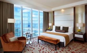 马尼拉Solaire Resort Entertainment City的酒店客房带一张床、椅子和窗户