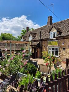 North LuffenhamThe horse and panniers guest house.的一座古老的石头房子,前面设有一个花园