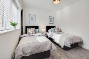 弗姆比Luxury 2-Bedroom Formby Property的配有2张床的白色墙壁和窗户。
