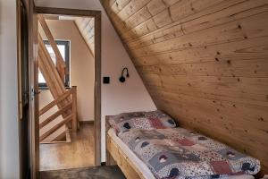 利波瓦拉尼Resort Bobrovník的一间卧室设有一张床和木墙