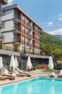 蒂瓦特Bayview Hills Luxury Residences的酒店设有带椅子和遮阳伞的游泳池