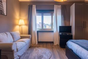 StupinigiVillaggio Junior - bambnb的带沙发和床的客厅以及窗户。