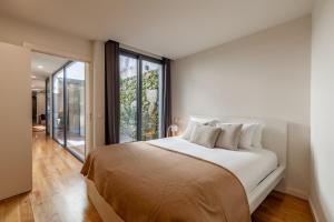 布拉加Yellow Lodge - Minho's Guest的一间卧室设有一张大床和一个大窗户