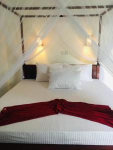 希克杜沃Anthony Guesthouse的卧室配有白色的床铺和白色的枕头
