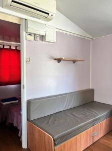 萨拉戈萨Bungalows Zaragoza Camping的红色窗帘的房间的一张床位