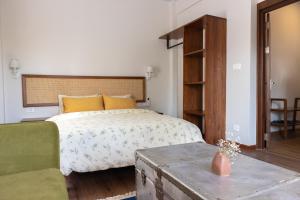加德满都Kibu Apartments的一间卧室配有一张床和一张绿色沙发