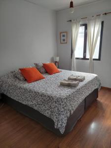 乌斯怀亚Habitación con Baño Privado - Frigo bar y sector para desayunar - Sin cocina的一间卧室配有带橙色枕头的床
