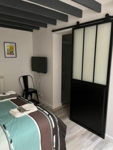 维耶尔宗Loft relais Cœur de France的一间卧室配有一张床,并在一间客房内配有电视。