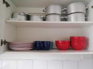德班PHAKADEHOMES的厨房里装满碗和盘子的架子