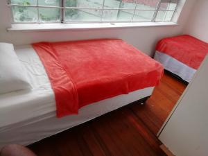 德班PHAKADEHOMES的一张带红色毯子的床,位于一个窗户的房间