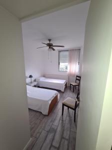 埃斯特角城apartamento en EDIFICIO URUGUAY 8VO的一间卧室配有两张床和吊扇