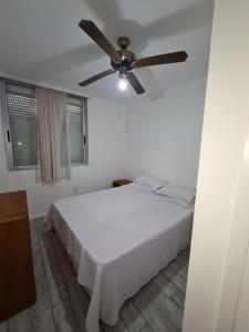 埃斯特角城apartamento en EDIFICIO URUGUAY 8VO的卧室配有白色的床和吊扇
