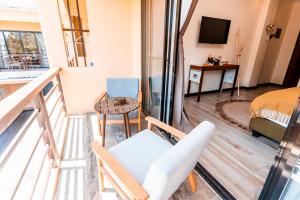 波尔多·格尼拉茉莉酒店的客房设有带椅子的阳台和电视。