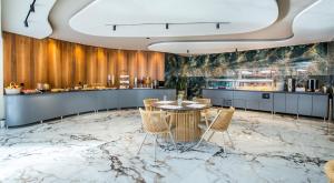 利迈纳里亚Green Bay的餐厅设有大理石地板和桌椅