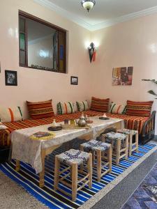 马拉喀什Riad dar sahrawi的客厅配有桌子和沙发