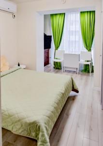 哈尔科夫Комфортная студия на Южном вокзале的一间卧室配有一张带绿色窗帘的大床
