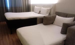 圣保罗圣保罗巴拉芬达宜必思尚品酒店的一间客房配有两张床和一张沙发