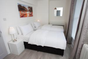 都柏林Temple Bar Essex Apartments的卧室配有白色的床和沙发