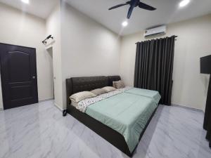 TuaranRestu Villa Homestay的一间卧室配有一张床和吊扇